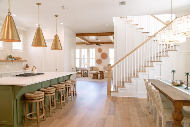 250 Beach Bike Way, Inlet Beach, FL 32461 - kitchen with green cabinetry, light wood-style flooring, decorative backsplash, light countertops, and a kitchen island