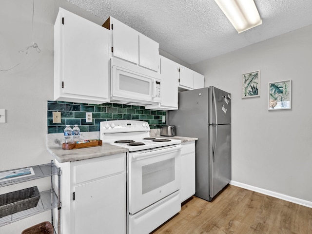 107 Surf Song Ln Unit A1, Miramar Beach, FL 32550 - kitchen with white appliances, light wood finished floors, light countertops, tasteful backsplash, and white cabinets