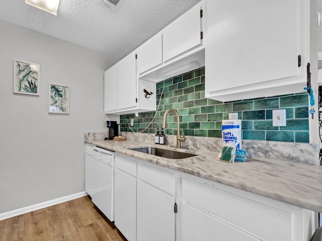 107 Surf Song Ln Unit A1, Miramar Beach, FL 32550 - kitchen featuring a sink, white dishwasher, baseboards, light wood-type flooring, and decorative backsplash