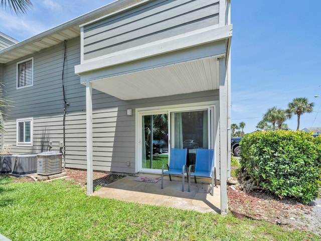 107 Surf Song Ln Unit A1, Miramar Beach, FL 32550 - rear view of house featuring a patio, central AC, and a yard