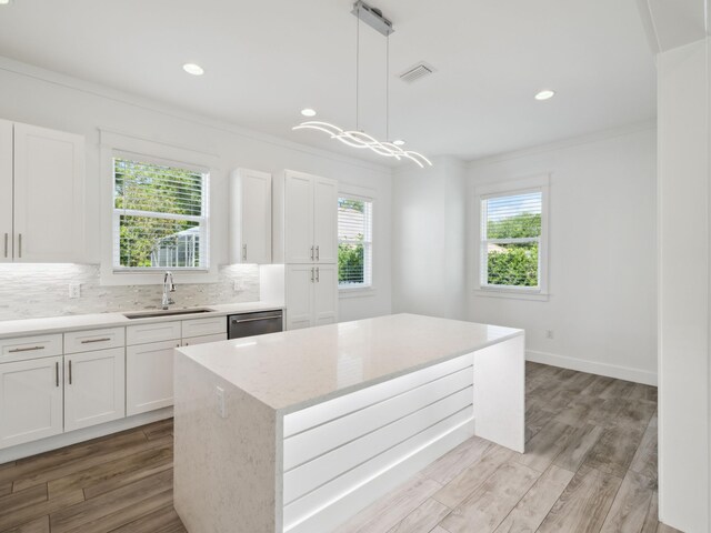 14 Bayshore Pines Ct, Miramar Beach, FL 32550 - kitchen featuring a sink, ornamental molding, healthy amount of natural light, tasteful backsplash, and white cabinets