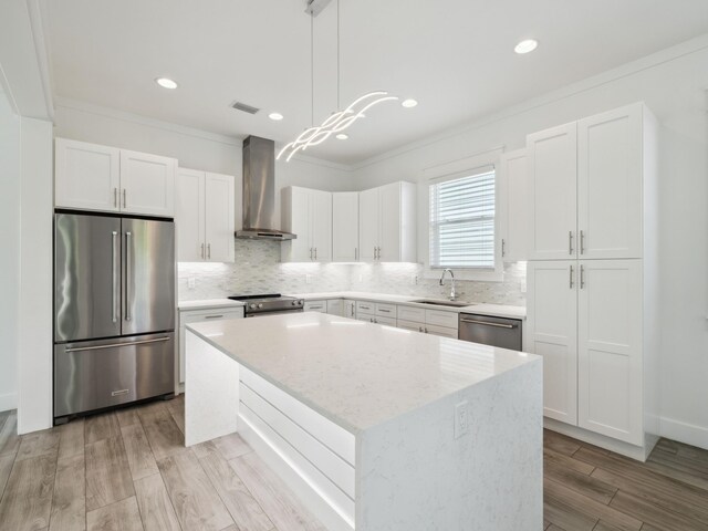 14 Bayshore Pines Ct, Miramar Beach, FL 32550 - kitchen featuring appliances with stainless steel finishes, wall chimney range hood, a sink, ornamental molding, and a kitchen island
