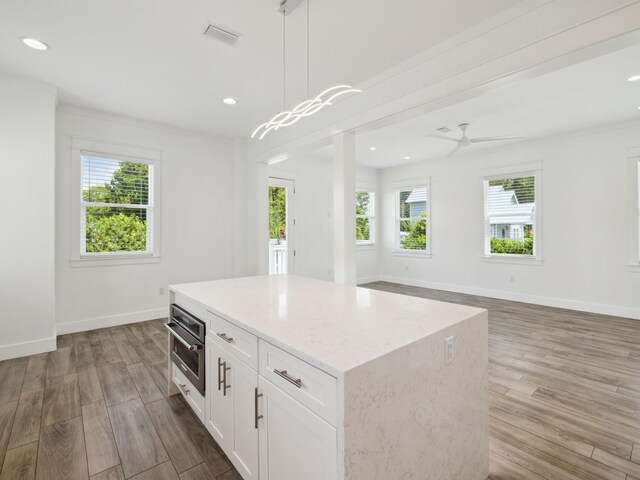 14 Bayshore Pines Ct, Miramar Beach, FL 32550 - kitchen with healthy amount of natural light, wood finished floors, white cabinets, a center island, and recessed lighting