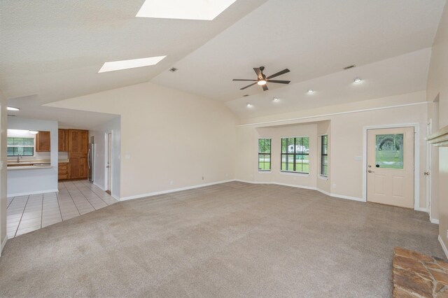 5903 Jack Stokes Rd, Baker, FL 32531 - unfurnished living room with light carpet, a skylight, vaulted ceiling, ceiling fan, and light tile patterned floors
