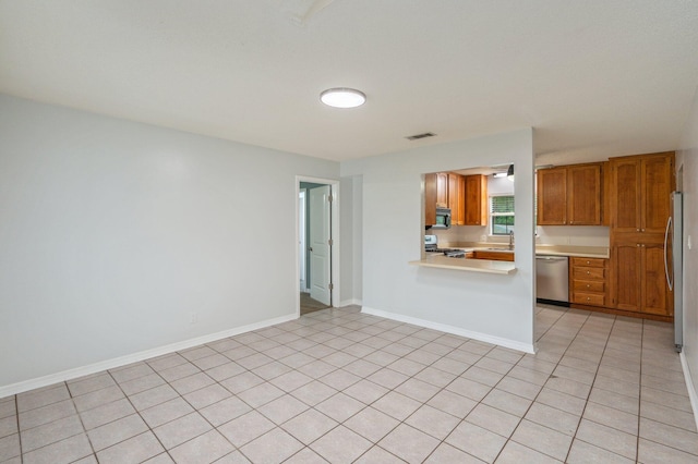 5903 Jack Stokes Rd, Baker, FL 32531 - kitchen with dishwasher, stove, light countertops, black microwave, and brown cabinetry