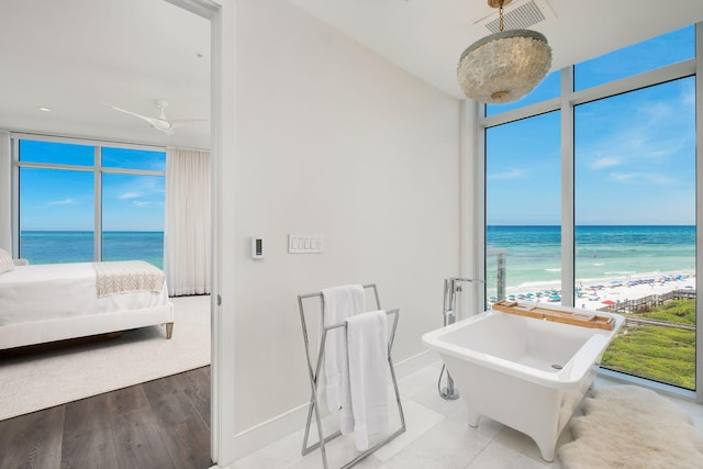 3820 E County Highway 30a Unit 408, Santa Rosa Beach, FL 32459 - ensuite bathroom with a water view, a wall of windows, a soaking tub, and wood finished floors