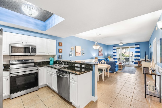 122 Seascape Dr Unit 208, Miramar Beach, FL 32550 - kitchen with appliances with stainless steel finishes, a peninsula, a sink, open floor plan, and light tile patterned floors
