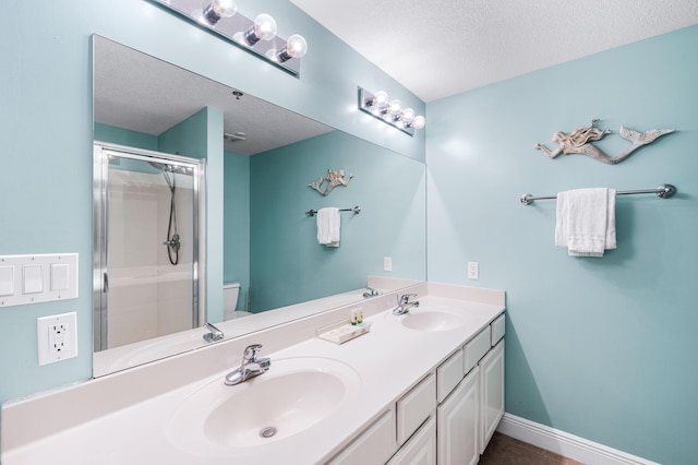 122 Seascape Dr Unit 208, Miramar Beach, FL 32550 - full bathroom with a textured ceiling, double vanity, a shower stall, toilet, and baseboards