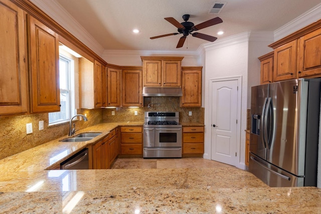 2007 Bayshore Dr, Niceville, FL 32578 - kitchen featuring stainless steel appliances, under cabinet range hood, crown molding, light stone countertops, and brown cabinetry