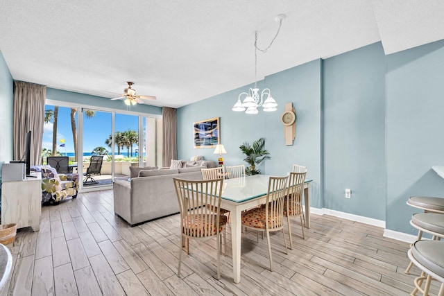 550 Tops L Beach Blvd # 102, Miramar Beach, FL 32550 - dining space featuring wood tiled floors, a ceiling fan, a chandelier, baseboards, and a textured ceiling