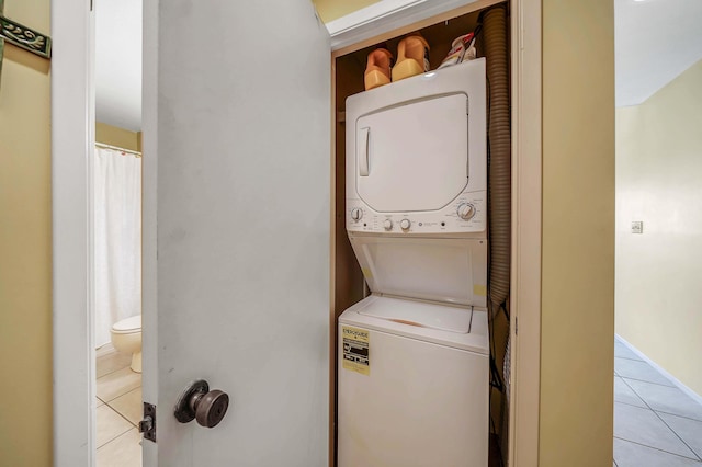 17614 Front Bch Unit E17, Panama City Beach, FL 32413 - laundry room featuring stacked washer / dryer and light tile patterned floors