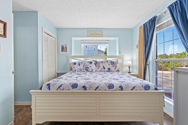 2384 Scenic Gulf Dr Unit 112, Miramar Beach, FL 32550 - bedroom featuring a closet, access to exterior, a textured ceiling, and baseboards