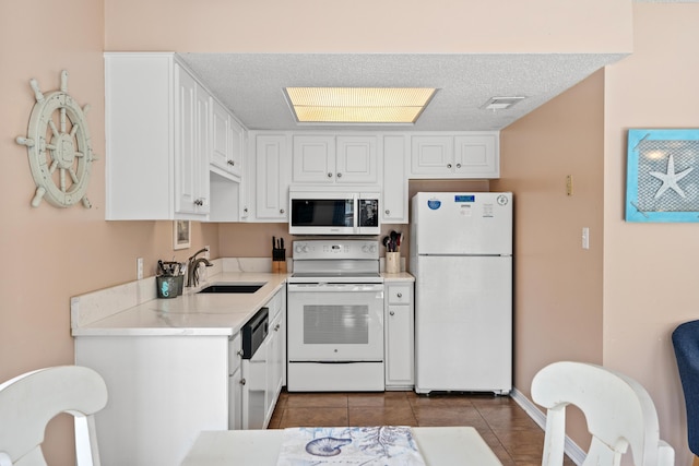2384 Scenic Gulf Dr Unit 112, Miramar Beach, FL 32550 - kitchen featuring white appliances, a sink, white cabinets, tile patterned flooring, and a textured ceiling