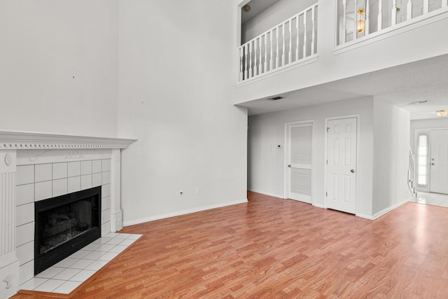 7 Citation Dr, Shalimar, FL 32579 - unfurnished living room featuring wood finished floors, a tile fireplace, and a high ceiling