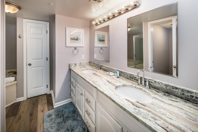 376 Santa Rosa Blvd Unit 101, Fort Walton Beach, FL 32548 - bathroom featuring double vanity, wood finished floors, and baseboards