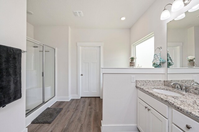 125 Hobson Ave, Crestview, FL 32539 - full bathroom featuring wood finished floors, a shower stall, vanity, and baseboards