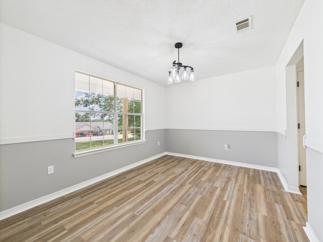 175 Villacrest Dr, Crestview, FL 32536 - unfurnished room featuring a chandelier, wood finished floors, baseboards, and a textured ceiling