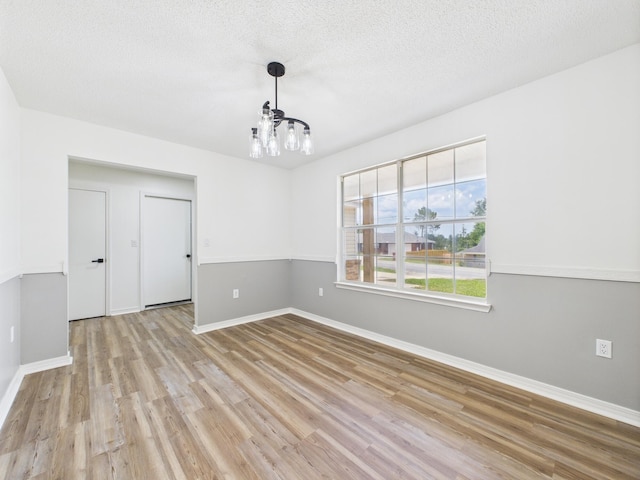 175 Villacrest Dr, Crestview, FL 32536 - unfurnished room with a chandelier, wood finished floors, baseboards, and a textured ceiling