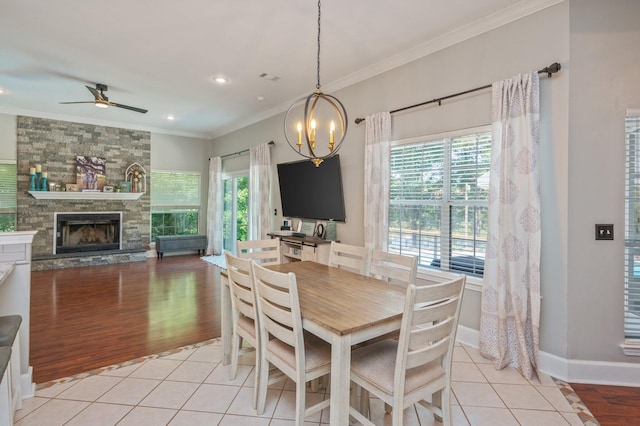 4680 Lovegrass Ln, Crestview, FL 32539 - dining area with ornamental molding, light wood-type flooring, a chandelier, ceiling fan, and a stone fireplace