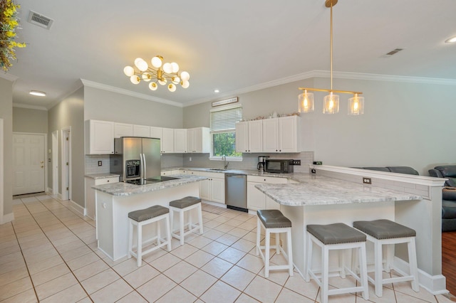 4680 Lovegrass Ln, Crestview, FL 32539 - kitchen featuring black appliances, a breakfast bar area, a peninsula, decorative backsplash, and light tile patterned floors