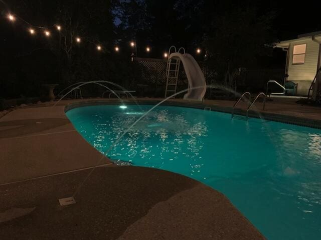 4680 Lovegrass Ln, Crestview, FL 32539 - pool at twilight with a water slide and a patio area