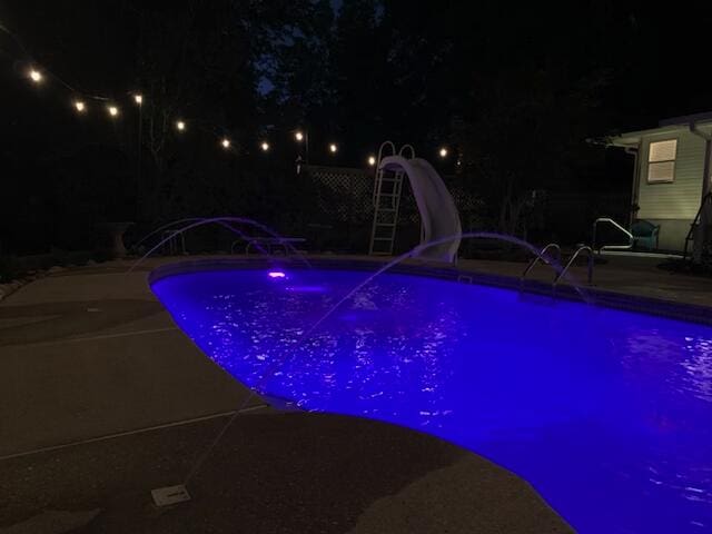 4680 Lovegrass Ln, Crestview, FL 32539 - pool at night with a water slide, a patio area, and an outdoor pool