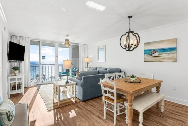 14701 Front Beach Rd Unit 1331, Panama City Beach, FL 32413 - dining space with a chandelier, wood finished floors, a ceiling fan, crown molding, and baseboards