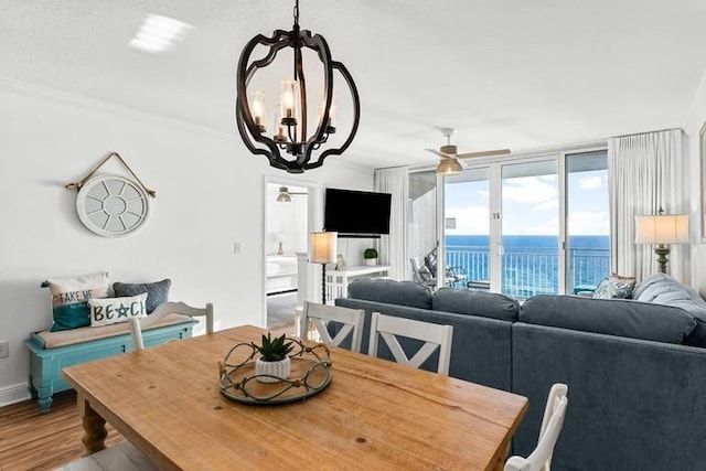14701 Front Beach Rd Unit 1331, Panama City Beach, FL 32413 - dining area with a ceiling fan, a chandelier, wood finished floors, baseboards, and ornamental molding