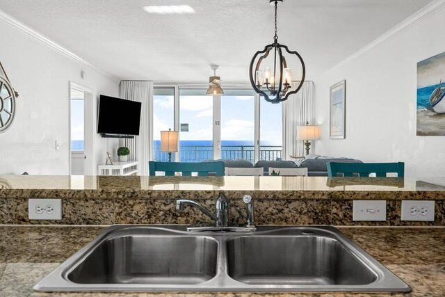 14701 Front Beach Rd Unit 1331, Panama City Beach, FL 32413 - kitchen with a sink, a chandelier, ornamental molding, dark stone counters, and pendant lighting