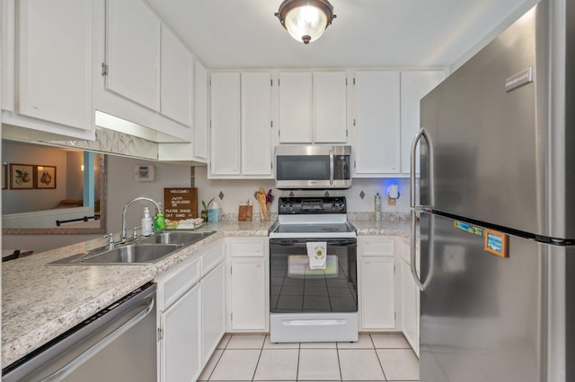 208 3rd St Unit J, Fort Walton Beach, FL 32548 - kitchen with stainless steel appliances, a sink, light tile patterned floors, light countertops, and white cabinets