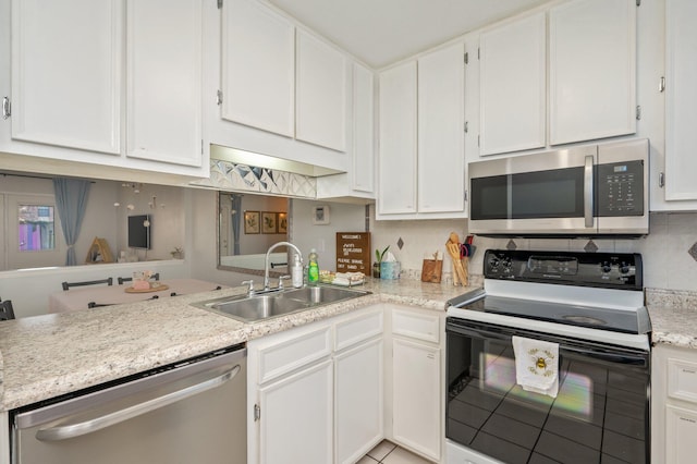 208 3rd St Unit J, Fort Walton Beach, FL 32548 - kitchen with stainless steel appliances, a sink, white cabinetry, light tile patterned floors, and a peninsula