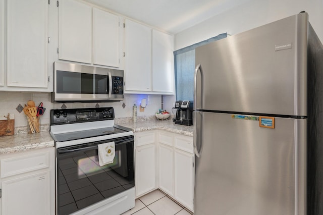 208 3rd St Unit J, Fort Walton Beach, FL 32548 - kitchen with appliances with stainless steel finishes, light tile patterned floors, white cabinets, and light stone countertops