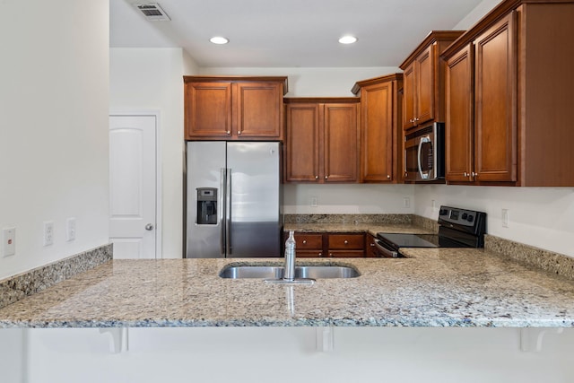 2131 Wilsons Plover Cir, Navarre, FL 32566 - kitchen featuring stainless steel appliances, a sink, light stone countertops, a peninsula, and recessed lighting