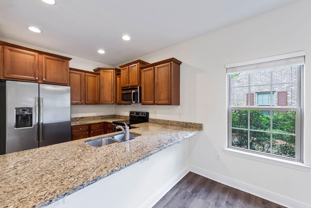 2131 Wilsons Plover Cir, Navarre, FL 32566 - kitchen featuring appliances with stainless steel finishes, a sink, dark wood-type flooring, light stone countertops, and baseboards