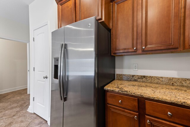 2131 Wilsons Plover Cir, Navarre, FL 32566 - kitchen with stainless steel refrigerator with ice dispenser, light stone counters, and brown cabinets