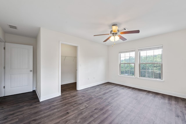 2131 Wilsons Plover Cir, Navarre, FL 32566 - unfurnished bedroom featuring dark wood-type flooring, baseboards, a walk in closet, and a closet