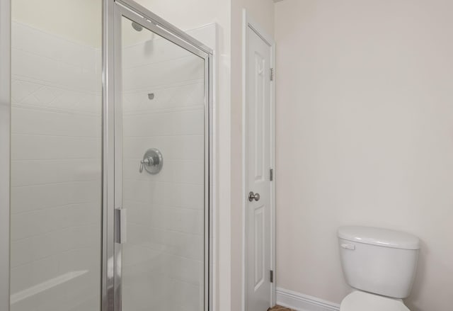 2131 Wilsons Plover Cir, Navarre, FL 32566 - bathroom featuring toilet, a shower stall, baseboards, and a closet