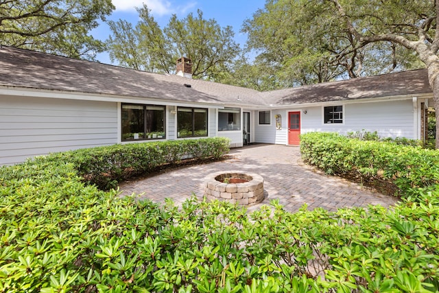 1127 Muirfield Way, Niceville, FL 32578 - view of front of house featuring an outdoor fire pit, a patio area, and a chimney