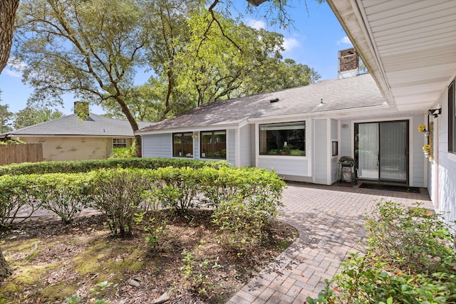 1127 Muirfield Way, Niceville, FL 32578 - back of property featuring a chimney, a patio area, and roof with shingles