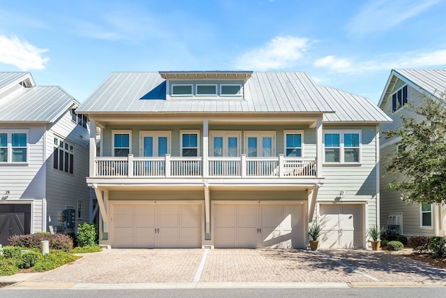 62 Dune Comet Ln Unit B, Inlet Beach, FL 32461 - view of front of house featuring a garage, decorative driveway, a balcony, and metal roof
