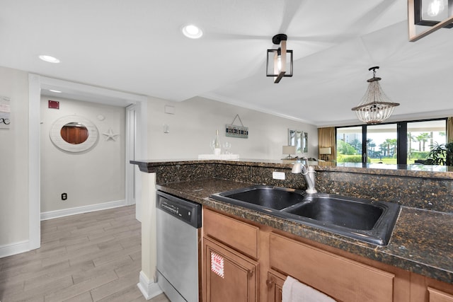 291 Scenic Gulf Dr Unit 201, Miramar Beach, FL 32550 - kitchen with stainless steel dishwasher, a sink, baseboards, brown cabinets, and light wood-type flooring