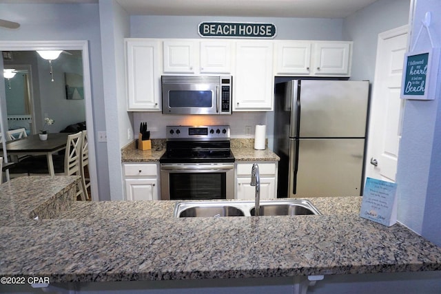 504 Lighthouse Rd Unit 504, Panama City Beach, FL 32407 - kitchen with stainless steel appliances, a sink, stone countertops, and white cabinets