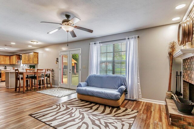 3544 State Highway 85, Laurel Hill, FL 32567 - living area featuring a brick fireplace, ceiling fan, light wood-type flooring, recessed lighting, and french doors