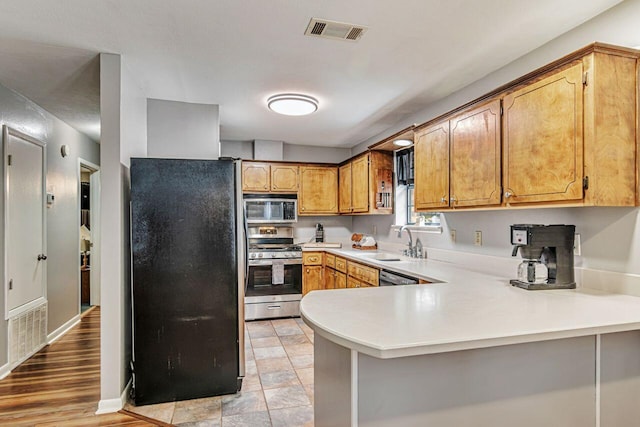 3544 State Highway 85, Laurel Hill, FL 32567 - kitchen featuring stainless steel appliances, a peninsula, light countertops, and brown cabinets