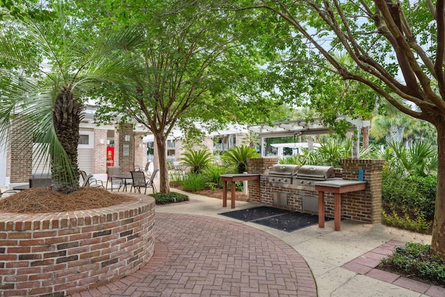 9100 Baytowne Wharf Blvd Unit 261, Miramar Beach, FL 32550 - surrounding community with an outdoor kitchen, a patio area, and a pergola