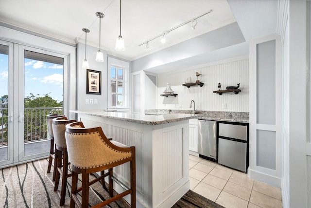 9100 Baytowne Wharf Blvd Unit 261, Miramar Beach, FL 32550 - kitchen with open shelves, white cabinets, light stone counters, hanging light fixtures, and crown molding
