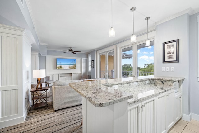 9100 Baytowne Wharf Blvd Unit 261, Miramar Beach, FL 32550 - kitchen with ornamental molding, french doors, a peninsula, light stone counters, and ceiling fan
