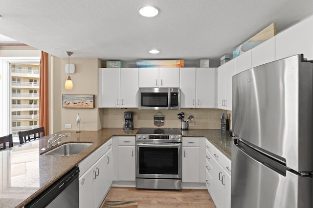 11800 Front Beach Rd Unit 1301, Panama City Beach, FL 32407 - kitchen featuring stainless steel appliances, a sink, white cabinets, a peninsula, and backsplash