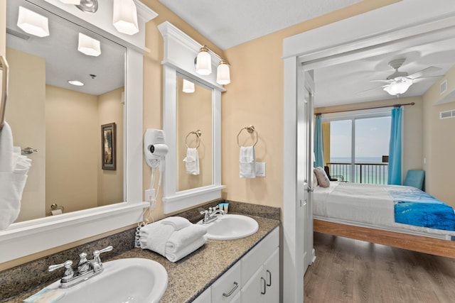 11800 Front Beach Rd Unit 1301, Panama City Beach, FL 32407 - bathroom featuring ensuite bath, double vanity, wood finished floors, ceiling fan, and a water view