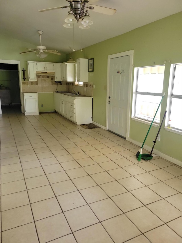 1989 Juniper Lake Rd, Defuniak Springs, FL 32433 - kitchen with backsplash, ceiling fan, under cabinet range hood, light tile patterned flooring, and white cabinetry